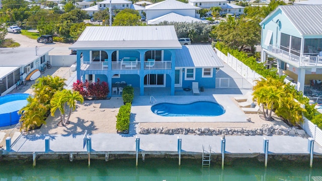 rear view of house featuring a balcony, a patio area, a fenced in pool, and a fenced backyard