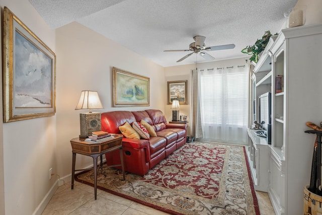 living room with light tile patterned floors, baseboards, a textured ceiling, and a ceiling fan