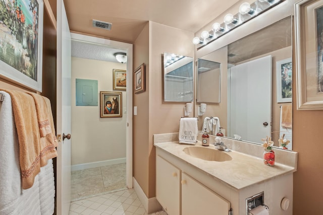 bathroom with visible vents, electric panel, tile patterned flooring, baseboards, and vanity