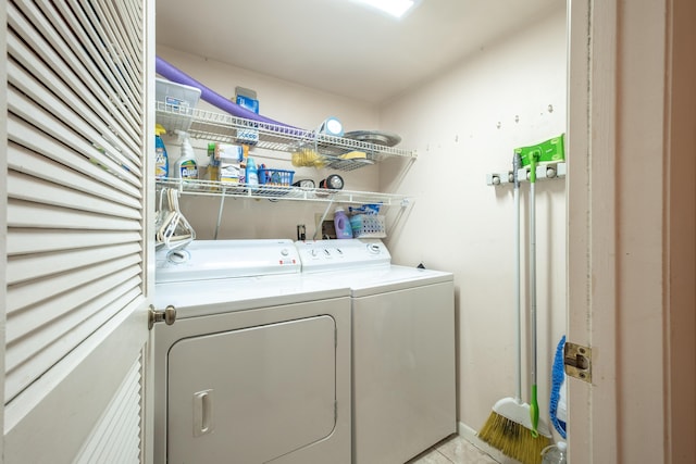 washroom featuring light tile patterned floors, laundry area, and washing machine and clothes dryer