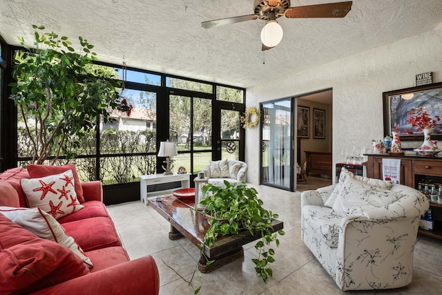 living area featuring tile patterned floors, a textured ceiling, ceiling fan, and a textured wall