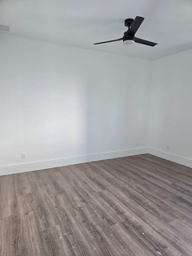 spare room featuring baseboards, ceiling fan, and wood finished floors