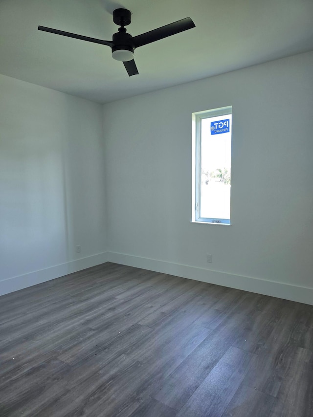 unfurnished room with dark wood-style floors, baseboards, and a ceiling fan