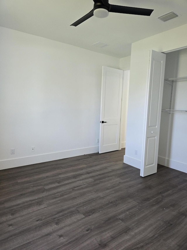 unfurnished bedroom with visible vents, dark wood-type flooring, and baseboards