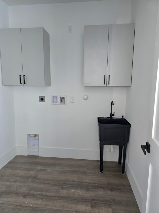 laundry area featuring dark wood finished floors, hookup for a washing machine, cabinet space, and electric dryer hookup