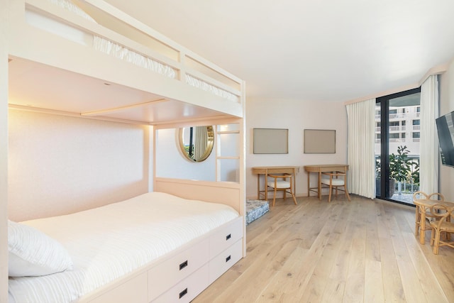 bedroom featuring expansive windows and hardwood / wood-style floors