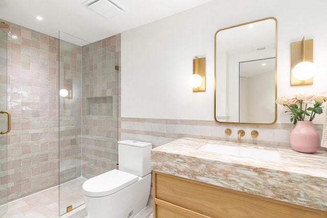 full bathroom featuring vanity, visible vents, a stall shower, tile walls, and toilet