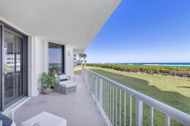 balcony with a water view and a view of the beach