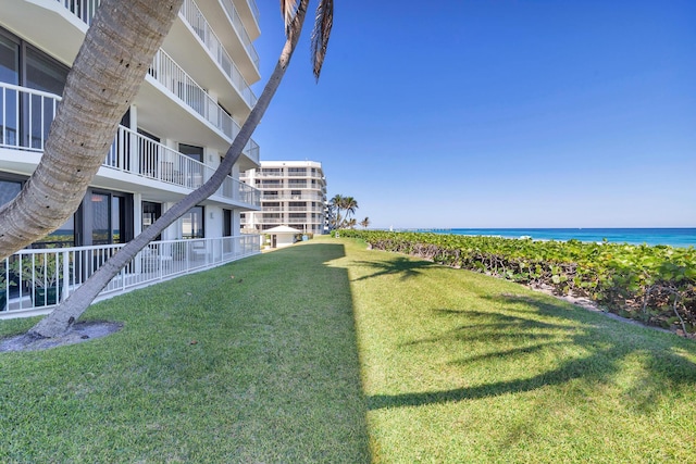 surrounding community with a view of the beach, a yard, and a water view