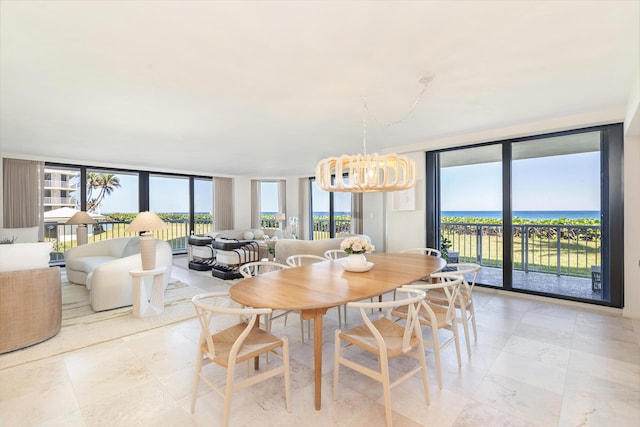 dining area featuring a wall of windows, an inviting chandelier, and a water view