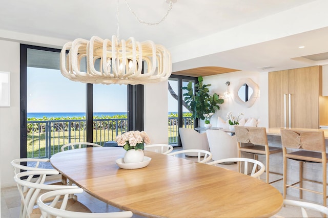 dining room featuring a water view and an inviting chandelier