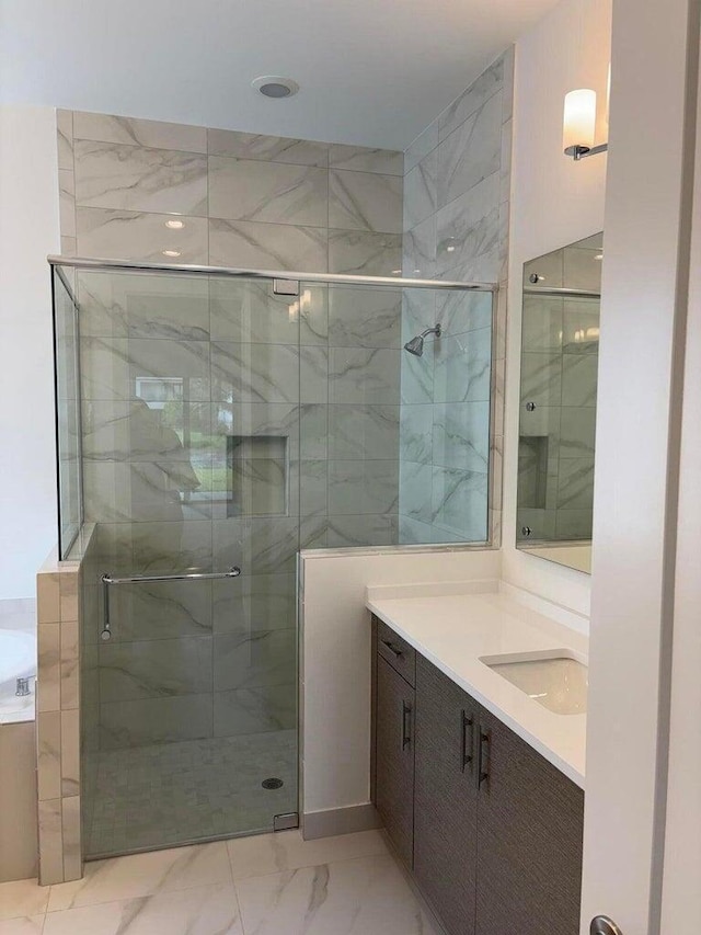 full bathroom featuring vanity, a shower stall, a garden tub, and marble finish floor