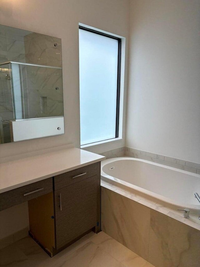 bathroom with vanity, a shower stall, and a garden tub