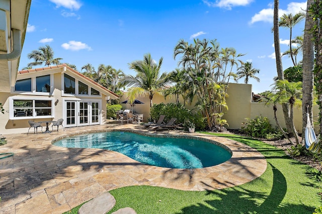 view of swimming pool with a patio, a fenced in pool, french doors, and fence