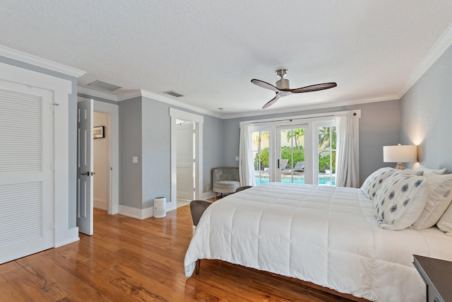 bedroom featuring visible vents, wood finished floors, access to exterior, and ornamental molding