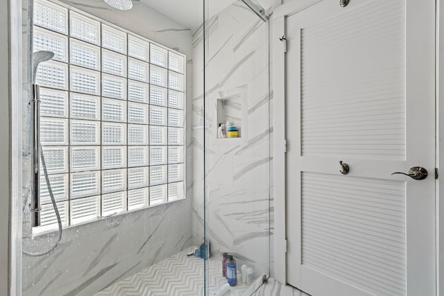 bathroom with a marble finish shower