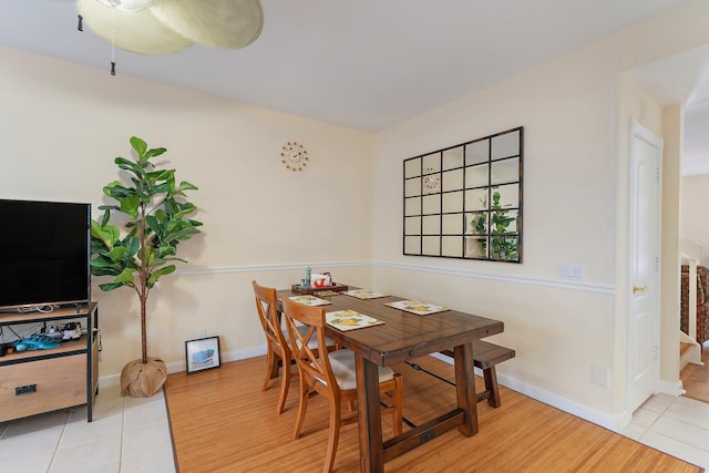 dining room featuring a ceiling fan, baseboards, and wood finished floors