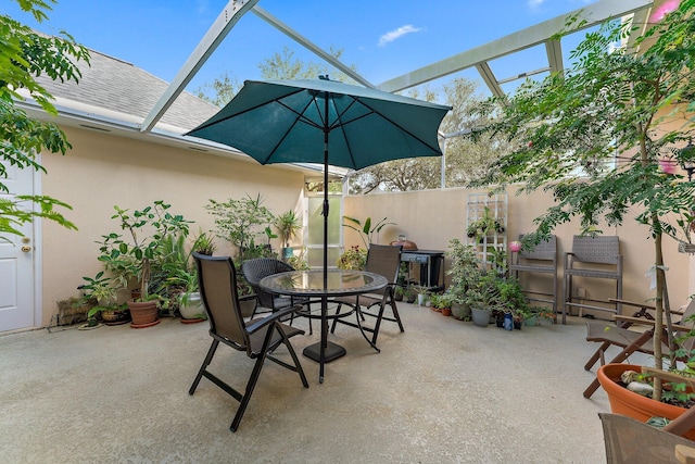 view of patio with glass enclosure and outdoor dining area