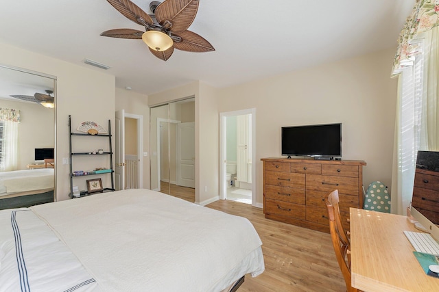 bedroom featuring light wood-type flooring, visible vents, ensuite bath, baseboards, and ceiling fan