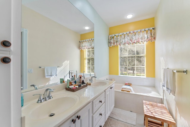 bathroom featuring double vanity, a garden tub, and a sink