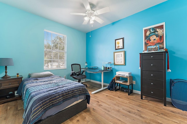 bedroom with ceiling fan, baseboards, and wood finished floors