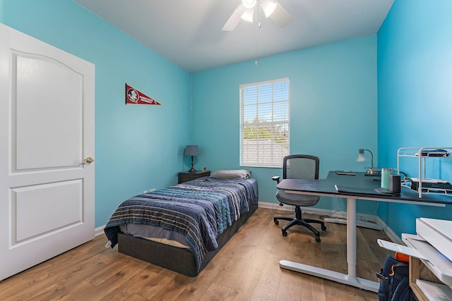 bedroom featuring a ceiling fan, baseboards, and wood-type flooring