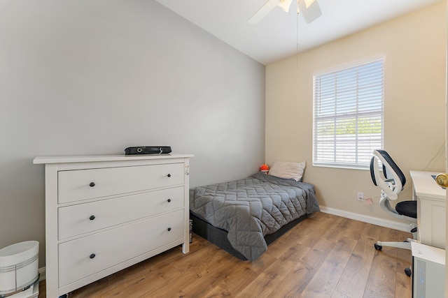 bedroom featuring a ceiling fan, lofted ceiling, baseboards, and light wood-type flooring