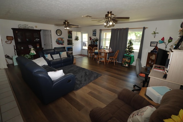 living area with visible vents, a textured ceiling, wood finished floors, and a ceiling fan