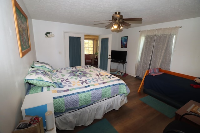 bedroom with a textured ceiling, wood finished floors, and a ceiling fan