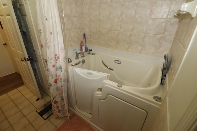 bathroom with tile patterned floors, curtained shower, and a washtub