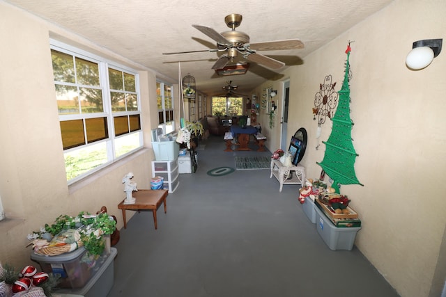 sunroom / solarium featuring a ceiling fan