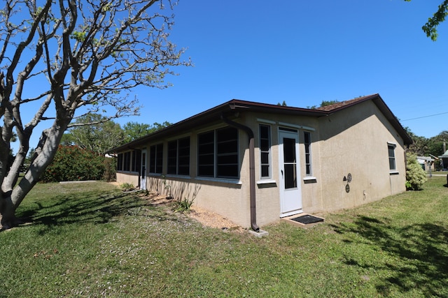 view of property exterior featuring stucco siding and a yard