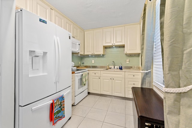 kitchen with white appliances, light tile patterned floors, a sink, light countertops, and backsplash