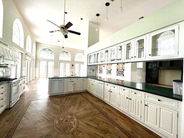 kitchen featuring white appliances, dark countertops, a high ceiling, and a ceiling fan