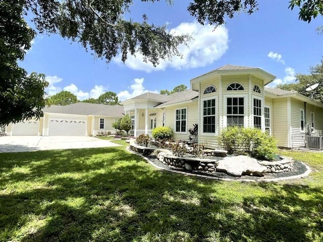 rear view of property with a lawn, concrete driveway, and a garage