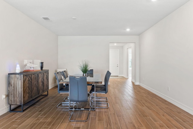 dining room with visible vents, baseboards, and wood finished floors