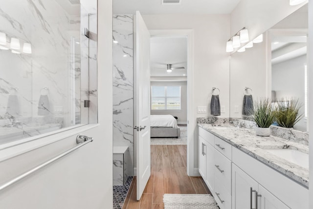 full bathroom featuring wood finished floors, a marble finish shower, ensuite bathroom, and a sink