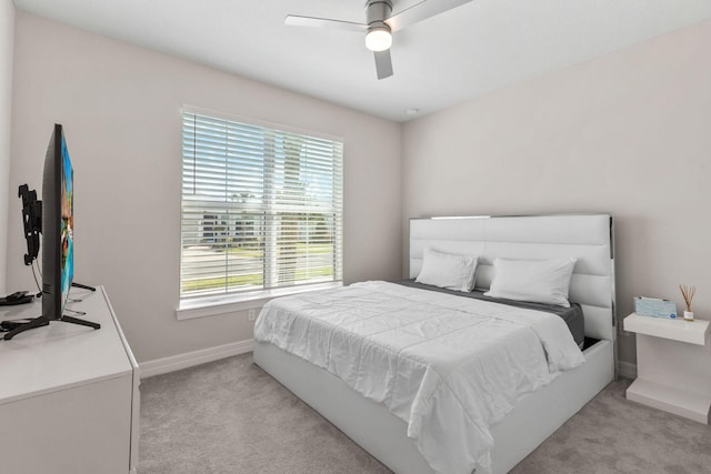 bedroom featuring baseboards, light carpet, and ceiling fan