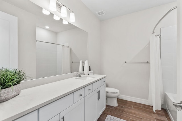 bathroom featuring toilet, shower / tub combo with curtain, wood tiled floor, baseboards, and vanity