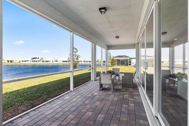 sunroom / solarium featuring a residential view and a water view