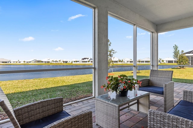 sunroom with a water view and a residential view