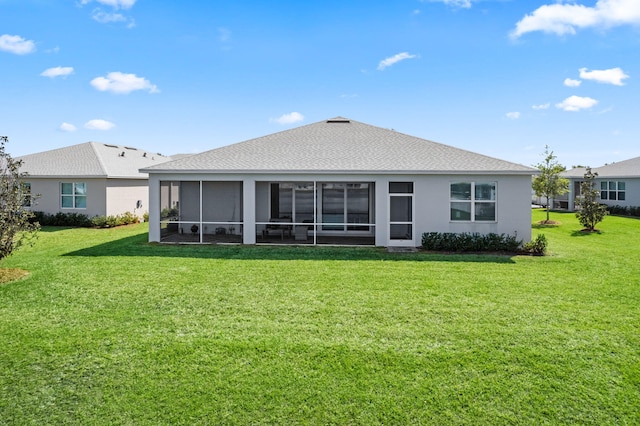 back of property with stucco siding, a lawn, a shingled roof, and a sunroom