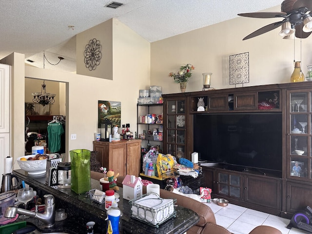 living room featuring visible vents, vaulted ceiling, light tile patterned floors, a textured ceiling, and a ceiling fan