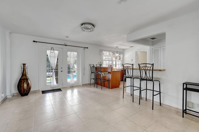 interior space with light tile patterned floors, french doors, baseboards, and visible vents