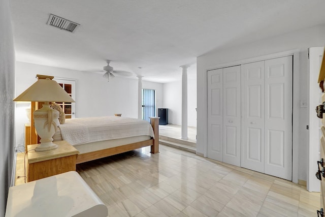 bedroom featuring decorative columns, visible vents, ceiling fan, and a closet