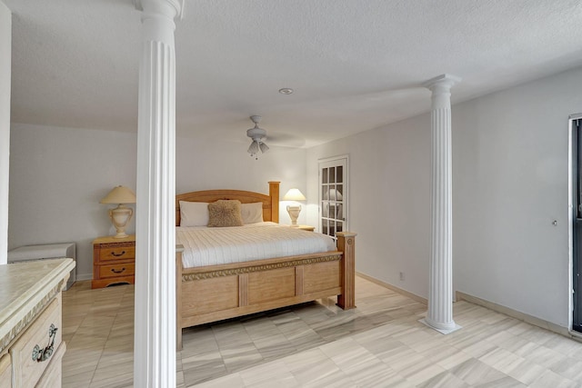 bedroom featuring decorative columns, baseboards, and a textured ceiling