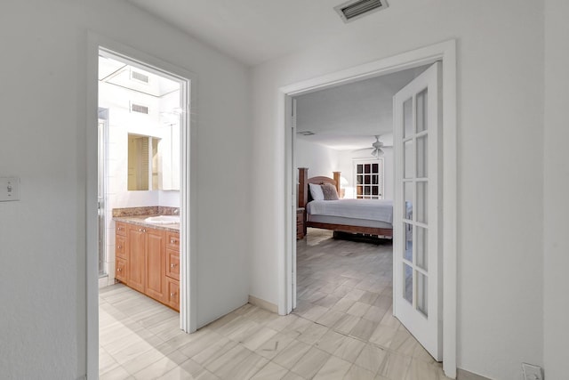 hallway featuring visible vents and a sink