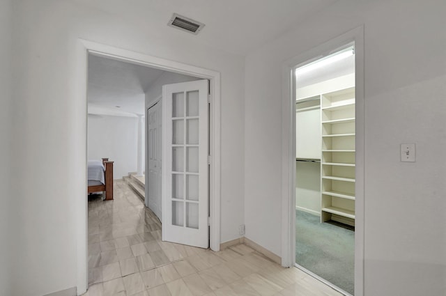 hallway featuring visible vents and baseboards