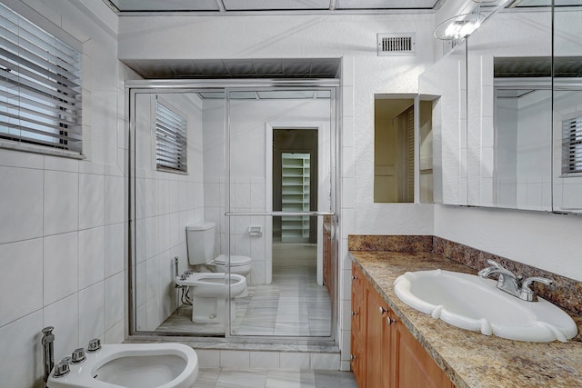 bathroom featuring visible vents, vanity, toilet, and a bidet