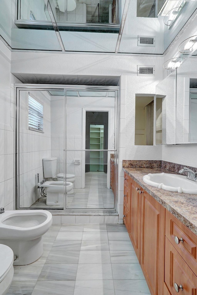 bathroom with visible vents, a bidet, toilet, and vanity